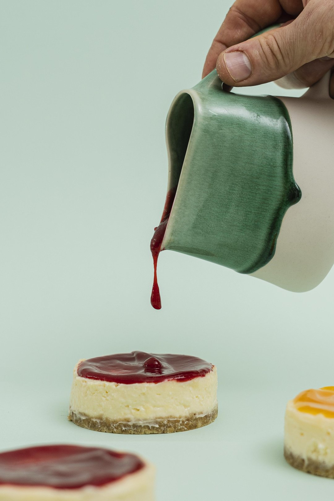 Coulis de fruits rouges versé sur un cheesecake